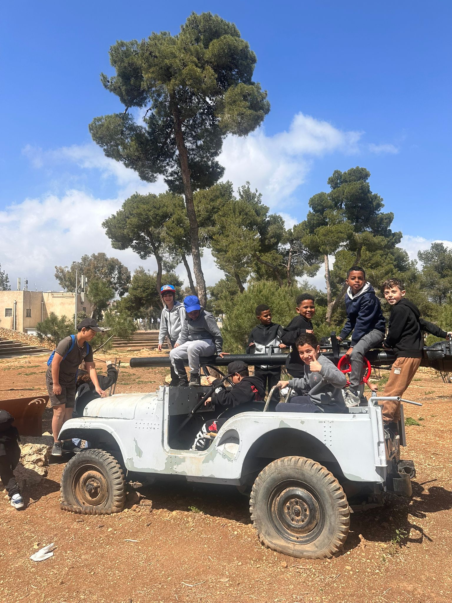 תלמידים בגבעת התחמושת לצד כלי רכב היסטורי