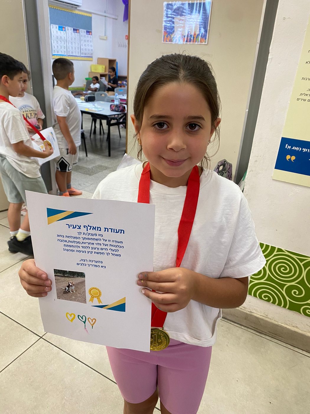 תלמידה מציגה תעודת הוקרה